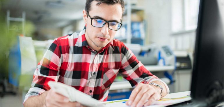 concentrated-designer-examining-quality-of-print-U4NWQDP.jpg
